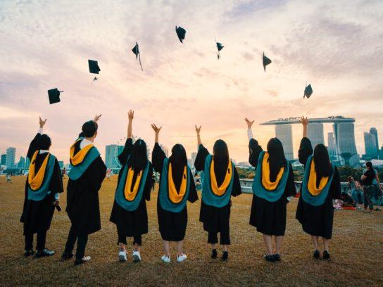 photo of graduates throwing caps in the air